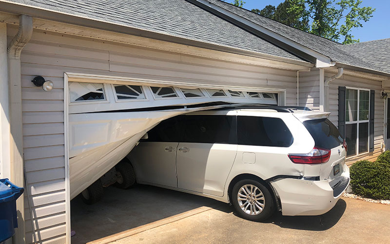 Emergency garage door repair technician securing a stuck-open door