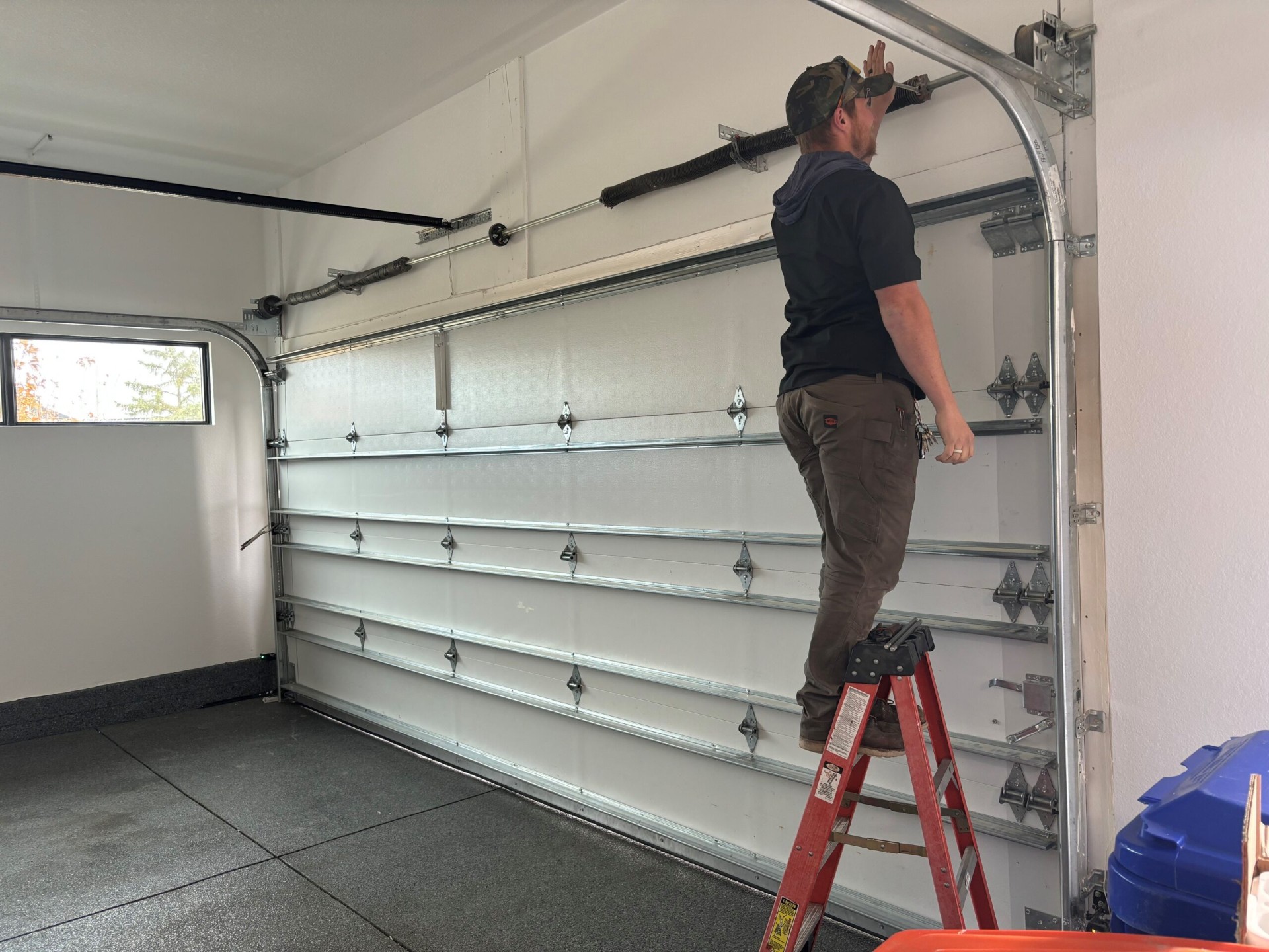 Garage door technician working on residential overhead door in Chipley, Florida