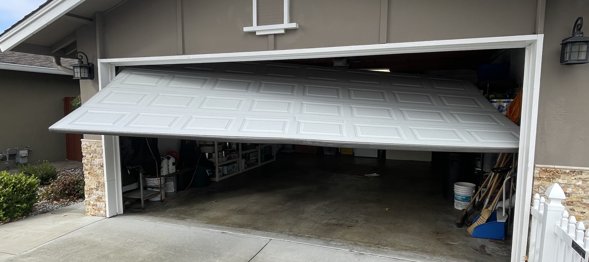 Off-track garage door repair with roller reset and track straightening
